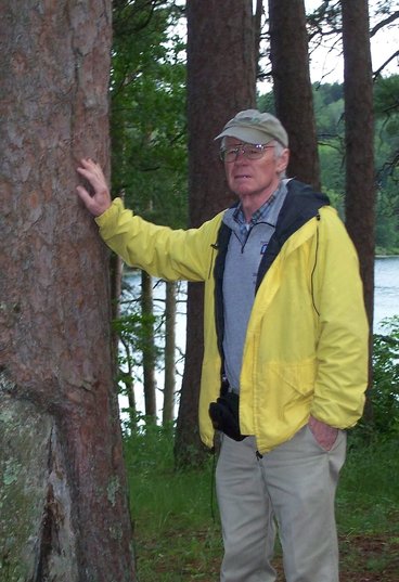 Man posing next to a tree in Preacher's Grove in Itasca, MN