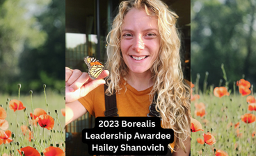 A photo of Hailey smiling and holding a Monarch butterfly is placed over a background photo of a field of poppies. Over that is the text, "2023 Borealis Leadership Awardee Hailey Shanovich."